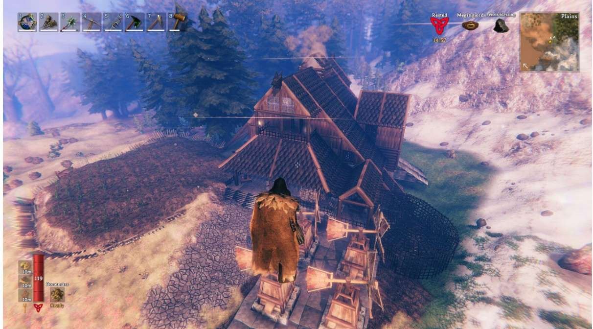 Valheim gameplay showing a Viking longhouse base in the Norse survival open world